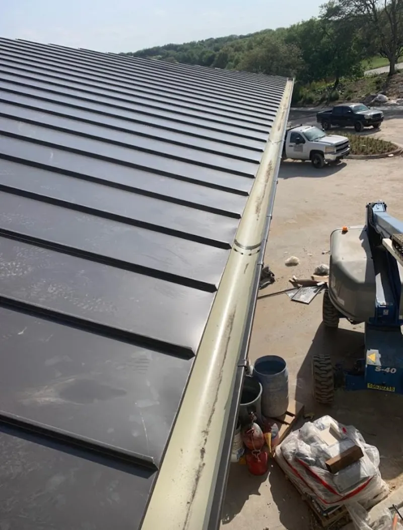 Standing seam panel and gutter detail on a metal roofing jobsite in Country Club Hills